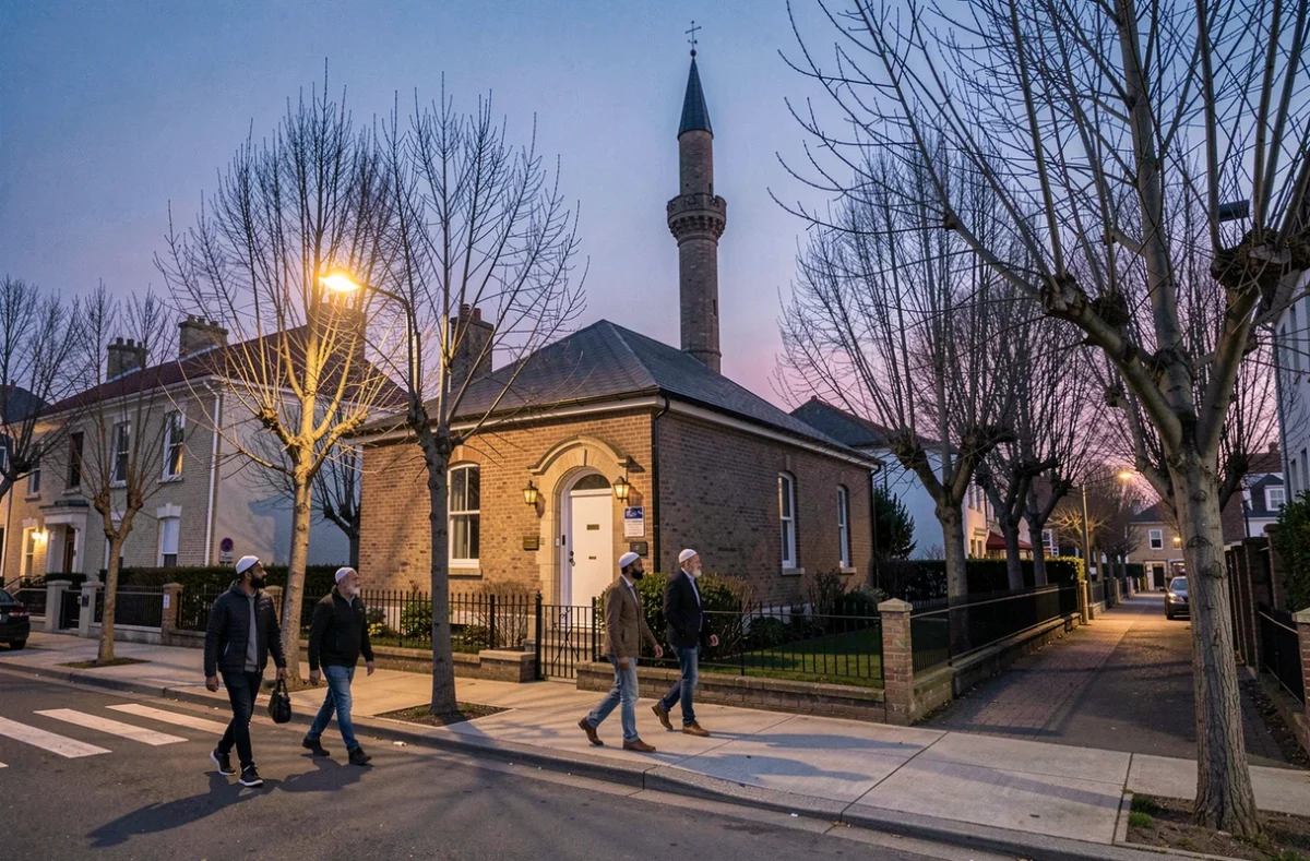 Façade d'une mosquée de banlieue parisienne au crépuscule avec des fidèles se dirigeant vers la prière du maghrib